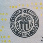 Detailed view of the US Federal Reserve System seal on currency with yellow digital numbers.