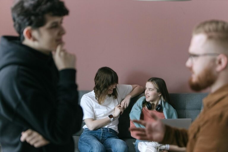 Young professionals engaging in a relaxed and collaborative office meeting with a warm and inviting atmosphere.